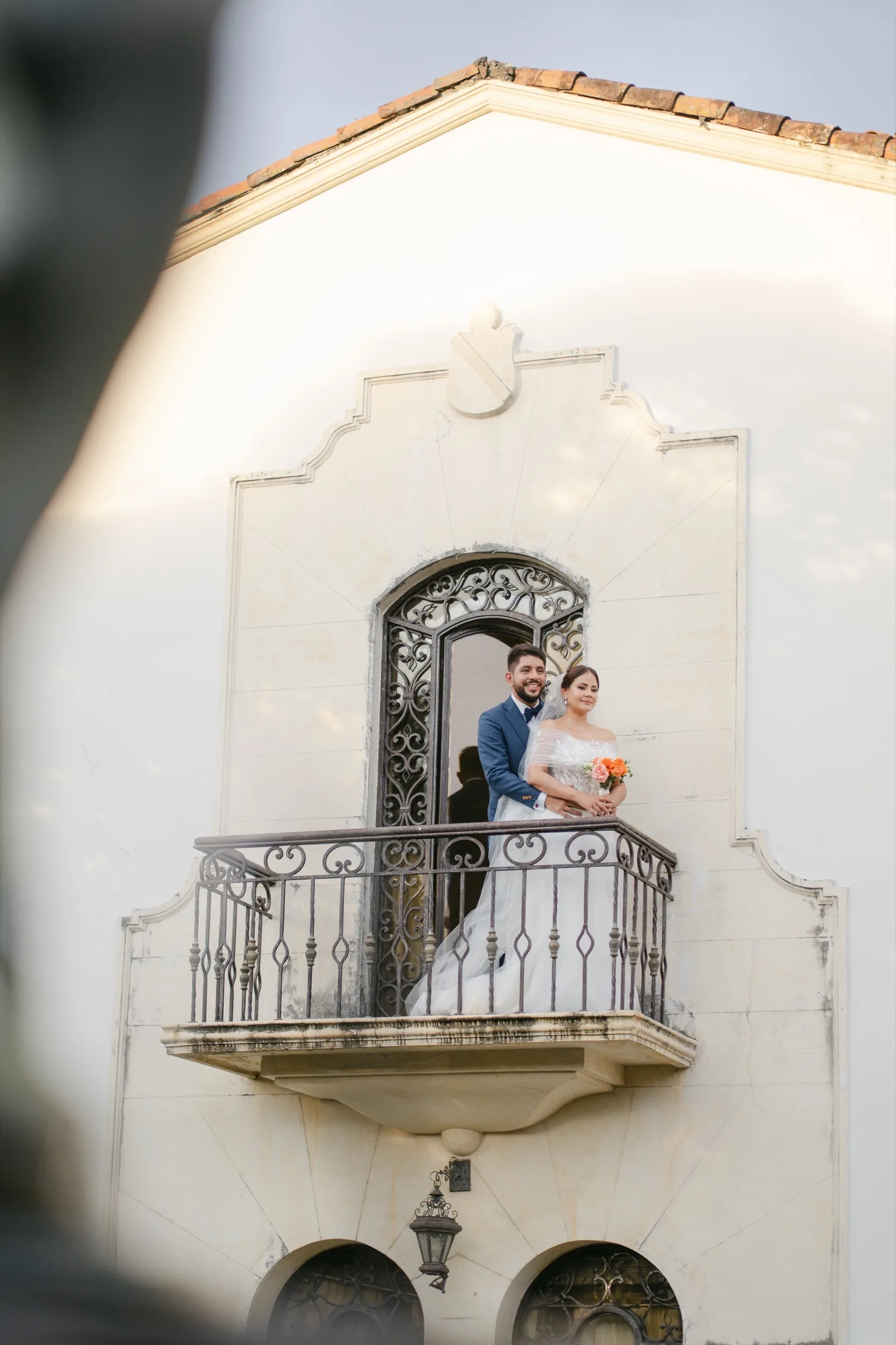 Bride and groom on colonial hacienda balcony